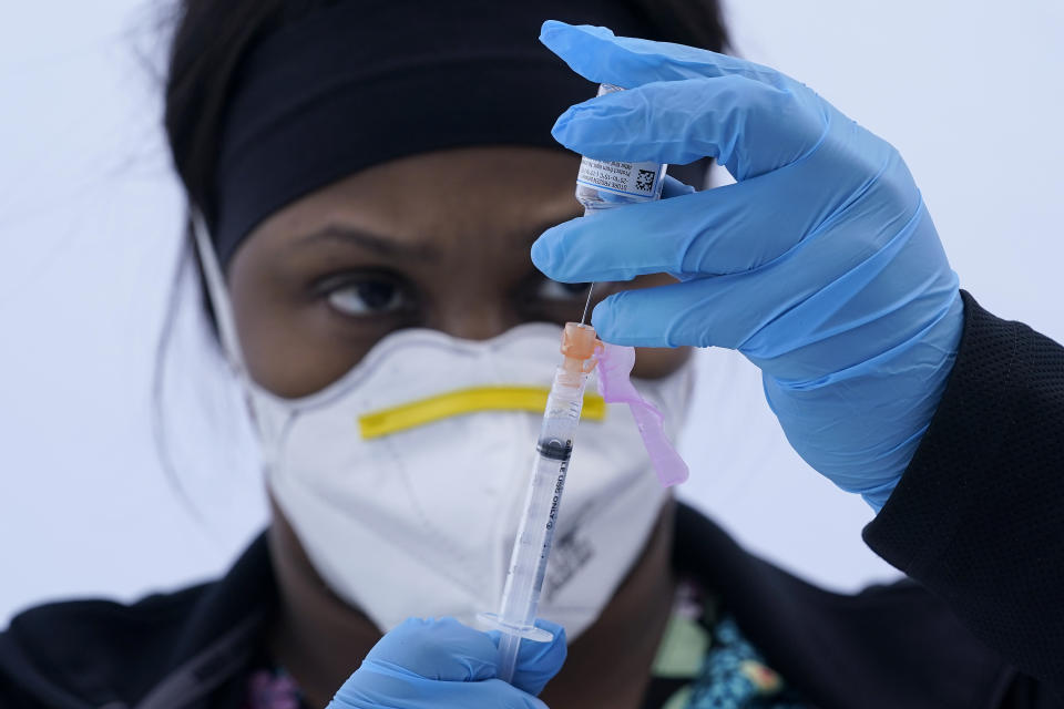 FILE - In this March 3, 2021, file photo, licensed vocational nurse Jelisa Stewart prepares a dose of the Moderna COVID-19 vaccine for farmworkers at a County of Santa Clara mobile vaccination clinic at Monterey Mushrooms during the coronavirus pandemic in Morgan Hill, Calif. In California, mobile clinics are helping to vaccinate farmworkers who may not have transportation to larger vaccination sites or who cannot navigate the state’s online signup portal. (AP Photo/Jeff Chiu, File)