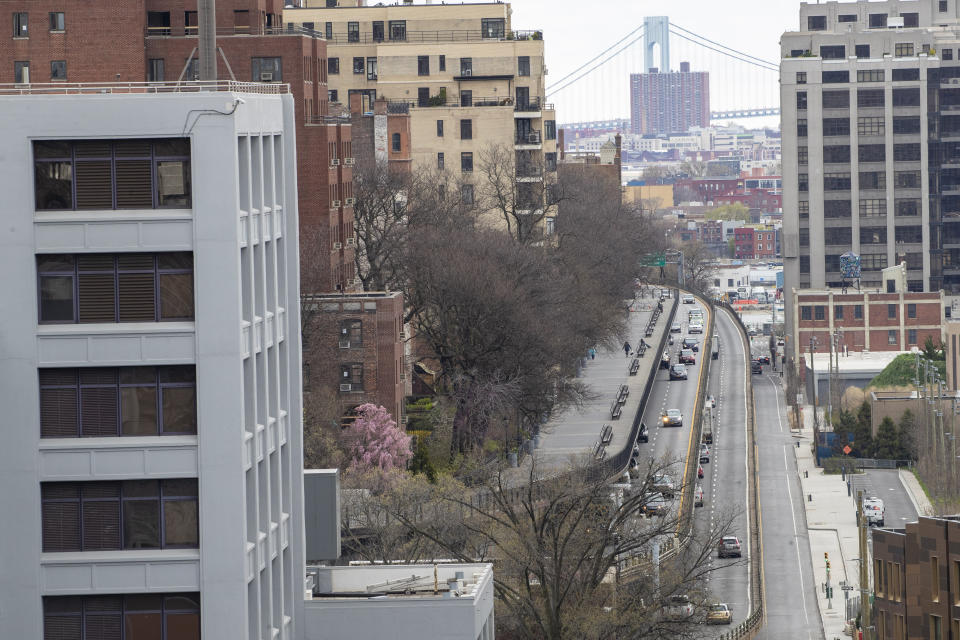 A person walks on the Brooklyn Heights promenade above the Brooklyn Queens Expressway Friday, April 10, 2020, in New York. The new coronavirus causes mild or moderate symptoms for most people, but for some, especially older adults and people with existing health problems, it can cause more severe illness or death. (AP Photo/Mary Altaffer)