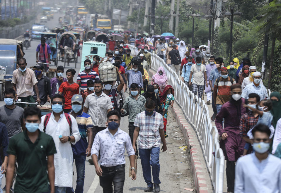 People wearing face masks a precaution against the coronavirus leave the city to travel to their native places ahead of Eid al-Fitr in Dhaka, Bangladesh, Friday, May 7, 2021. India's surge in coronavirus cases is having a dangerous effect on neighboring Bangladesh. Health experts warn of imminent vaccine shortages just as the country should be stepping up its vaccination drive, and as more contagious virus variants are beginning to be detected. (AP Photo/Mahmud Hossain Opu)