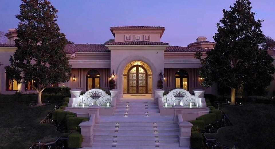 The same entryway at night, with the fountains lit by lights beneath the water