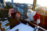 Guests enjoy dinner at the table "Santa in the sky", lifted by a crane and decorated to match the appearance of a "Santa Sleigh" as part as the Christmas festivities, in Brussels, Belgium, November 25, 2016. Picture taken November 25, 2016. REUTERS/Yves Herman