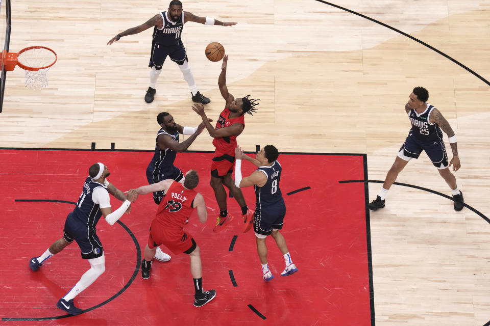 Toronto Raptors' Immanuel Quickley shoots on the Dallas Mavericks defense during the first half of an NBA basketball game in Toronto on Wednesday, Feb. 28, 2024. (Chris Young/The Canadian Press via AP)