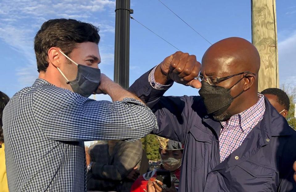 Democratic U.S. Senate candidates Jon Ossoff, right, and Raphael Warnock, left, of Georgia tap elbows during a rally for supporters on Nov. 15, 2020 in Marietta, Georgia.