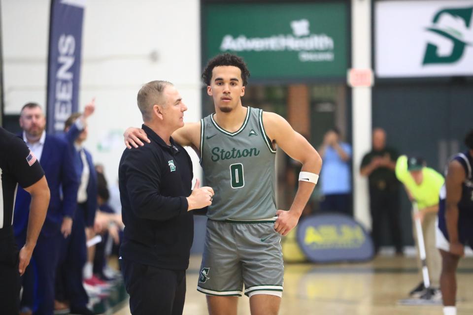 Stetson coach Donnie Jones (left) speaks with Alec Oglesby (0) during a stoppage in play as the Hatters beat Queens 83-71 in an ASUN quarterfinal on Tuesday, March 5, 2024 in DeLand. Jones has coached in the NCAA Tournament many times as an assistant, but this is his first appearance as a head coach.