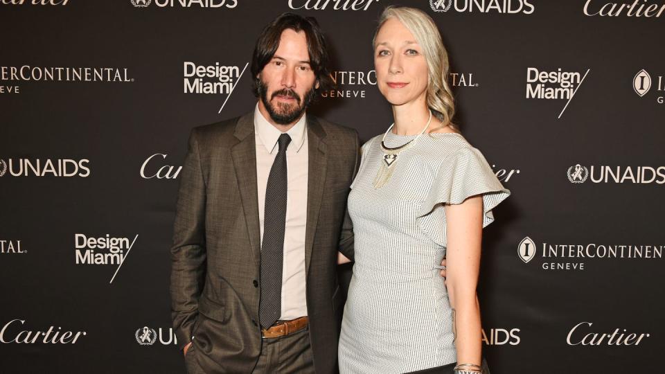 Keanu Reeves and Alexandra Grant pose for cameras on the red carpet.