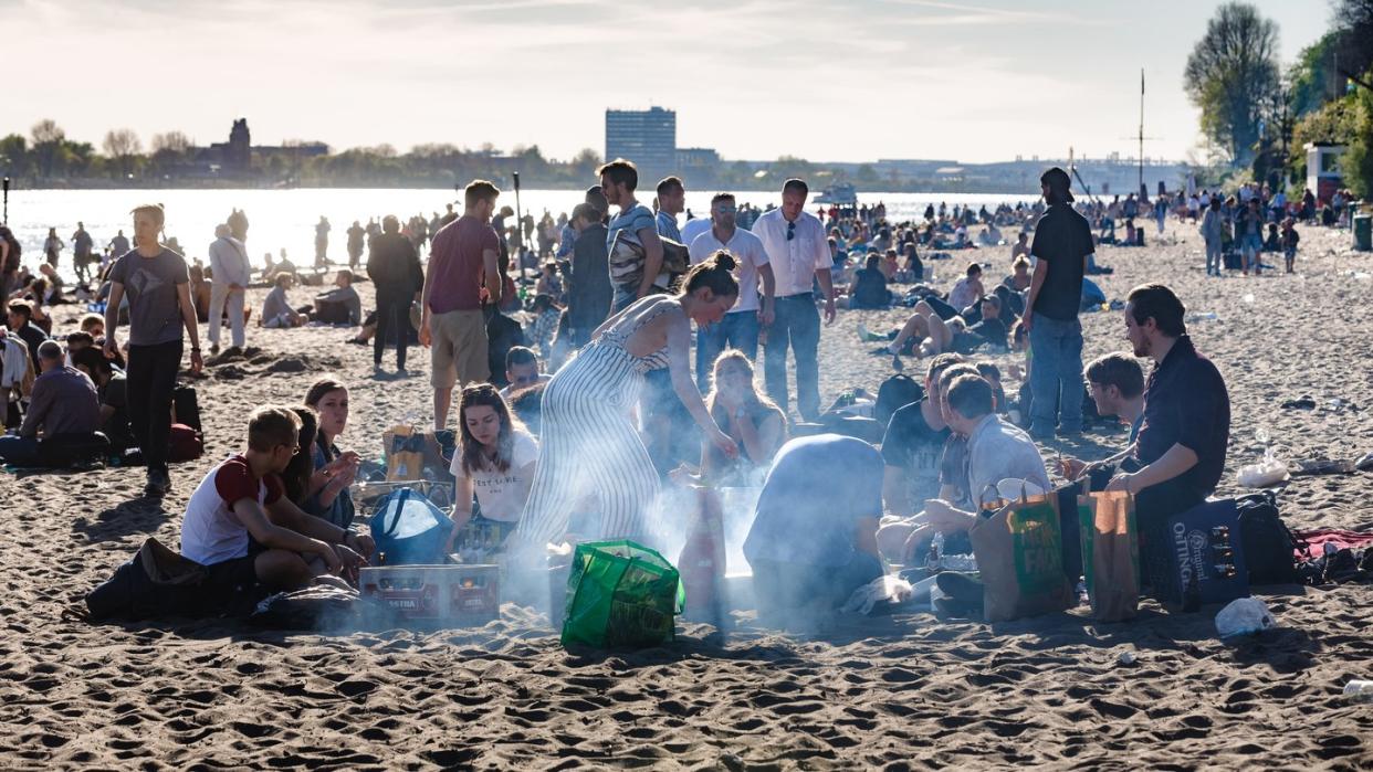 Hier sind Grillschalen aus Aluminium alltäglich: Menschen brutzeln am Elbstrand im Hamburg.