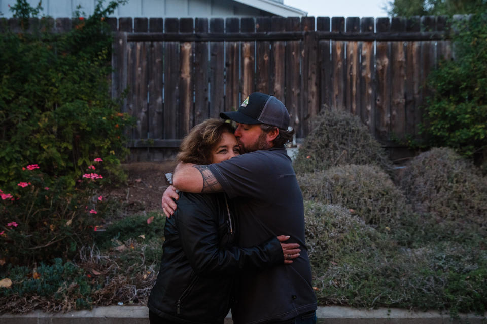 Raquel Salorio and Mike Kurtz hug in her son Joseph's backyard in San Diego. (Photo: Ariana Drehsler for HuffPost)