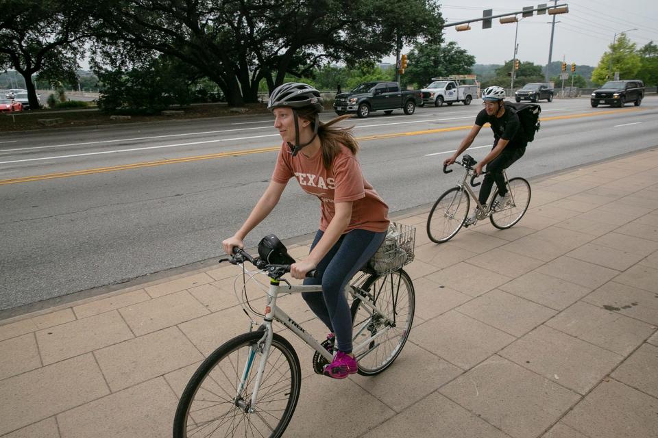 Anna Huntington and Erick Avila ride past City Hall last month. Austin-area leaders encourage residents to rely more on bicycles as their primary form of transportation to help reduce pollution and traffic.