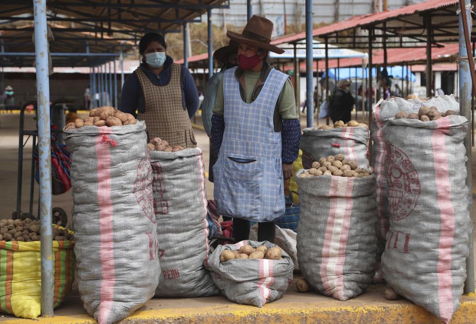 Potato farmer Herlinda lluac, center, waits for customers in a market in Cusco, Peru, Saturday, Oct. 31, 2020. Small farmers in Peru provide a majority of the food that ends up on the South American nation's dinner tables. (AP Photo/Martin Mejia)