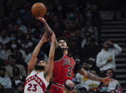 Toronto Raptors guard Fred VanVleet (23) battles for the ball against Chicago Bulls guard Lonzo Ball (2) as Bulls guard Alex Caruso (6) looks on during first-half NBA basketball game action in Toronto, Monday, Oct. 25, 2021. (Nathan Denette/The Canadian Press via AP)