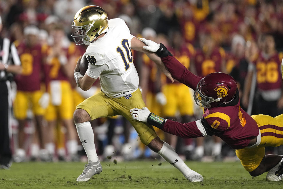 Notre Dame quarterback Drew Pyne, left, avoids being sacked by Southern California defensive end Korey Foreman during the first half of an NCAA college football game Saturday, Nov. 26, 2022, in Los Angeles. (AP Photo/Mark J. Terrill)