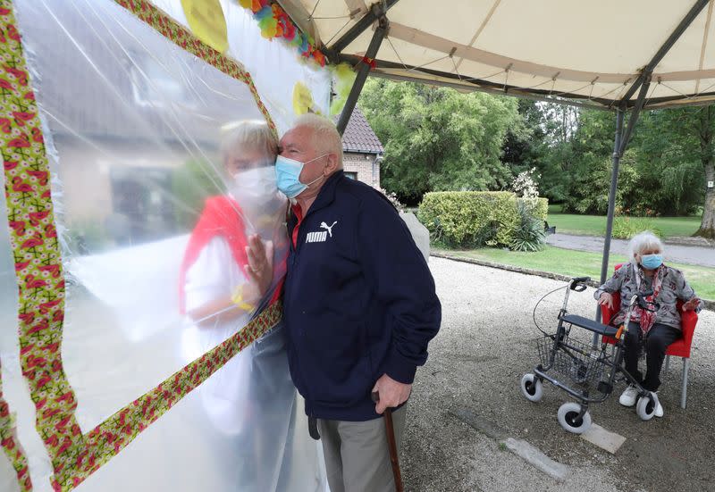 Residents at Belgian nursing home "Le Jardin de Picardie" enjoy hugs and cuddle through a wall made with plastic sheets to protect against potential COVID-19 infection in Peruwelz