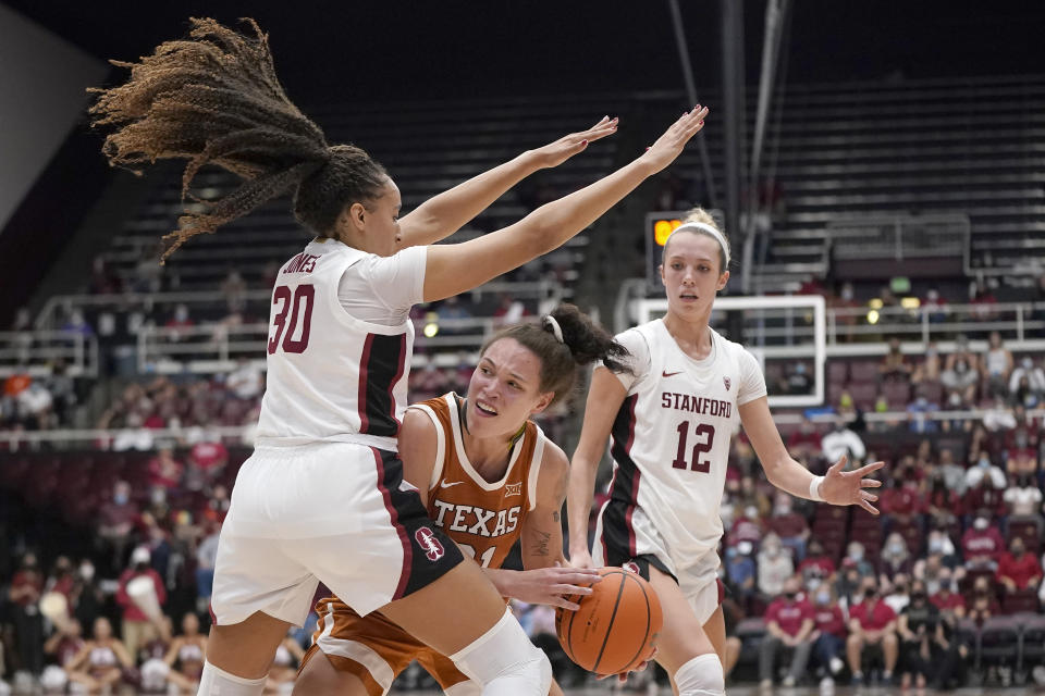 Texas guard Audrey Warren, middle, is defended between Stanford guard Haley Jones (30) and guard Lexie Hull (12) during the second half of an NCAA college basketball game in Stanford, Calif., Sunday, Nov. 14, 2021. (AP Photo/Jeff Chiu)