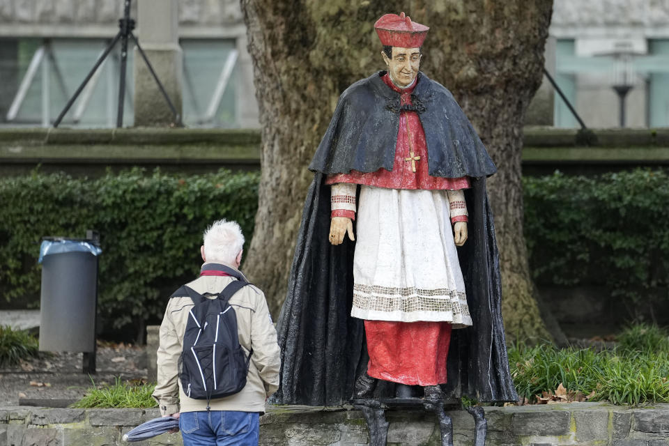 A man watches the monument of German cardinal Franz Hengsbach beside the cathedral in the city center of Essen, western Germany, Friday, Sept. 22, 2023. The Catholic Church is investigating allegations of sexual abuse by the late cardinal over 30 years after his death. (AP Photo/Martin Meissner)