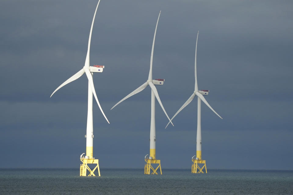 Three wind turbines stand in the ocean. (Source: Getty)