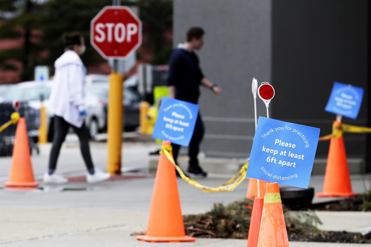 Information signs are posted before entering a Walmart store in Vernon Hills, Ill., Saturday, April 4, 2020. Walmart will limit the number of customers allowed and create one-way traffic inside its stores during coronavirus pandemic.