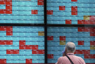 A man looks at an electronic stock board showing Japan's Nikkei 225 index at a securities firm in Tokyo Friday, Aug. 16, 2019. Asian shares were mixed Friday as turbulence continued on global markets amid ongoing worries about U.S.-China trade conflict. (AP Photo/Eugene Hoshiko)