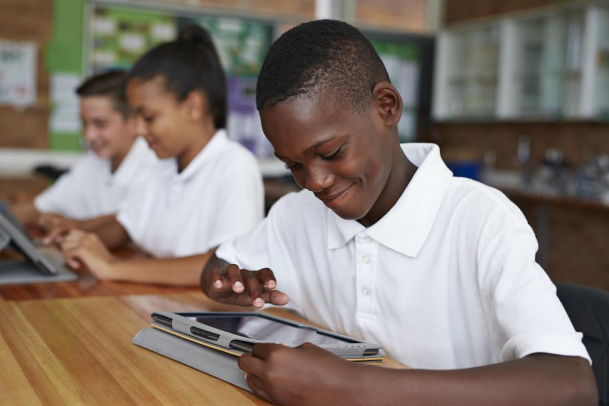 <span class="caption">High-tech tools can help African American children avoid drugs and alcohol, honor their racial heritage, and remain optimistic.</span> <span class="attribution"><a class="link " href="https://www.gettyimages.com/detail/photo/happy-school-kid-scrolling-on-tablet-royalty-free-image/548929065?adppopup=true" rel="nofollow noopener" target="_blank" data-ylk="slk:Getty Images / Klaus Vedfelt;elm:context_link;itc:0;sec:content-canvas">Getty Images / Klaus Vedfelt</a></span>