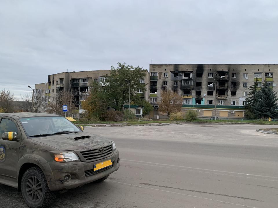 A vehicle near destroyed apartments in Izium. 