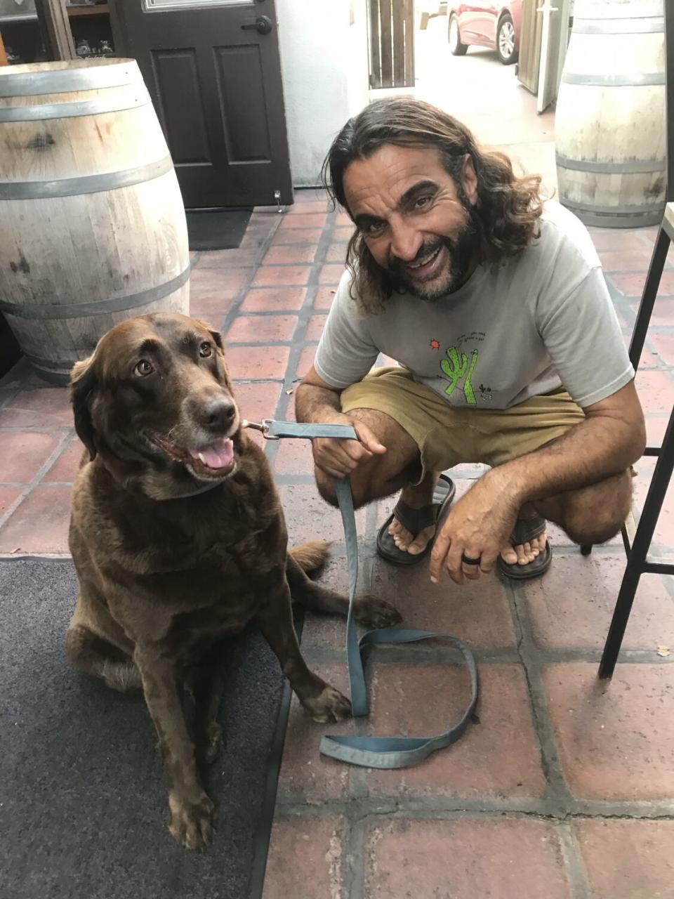 A man poses with his dog.