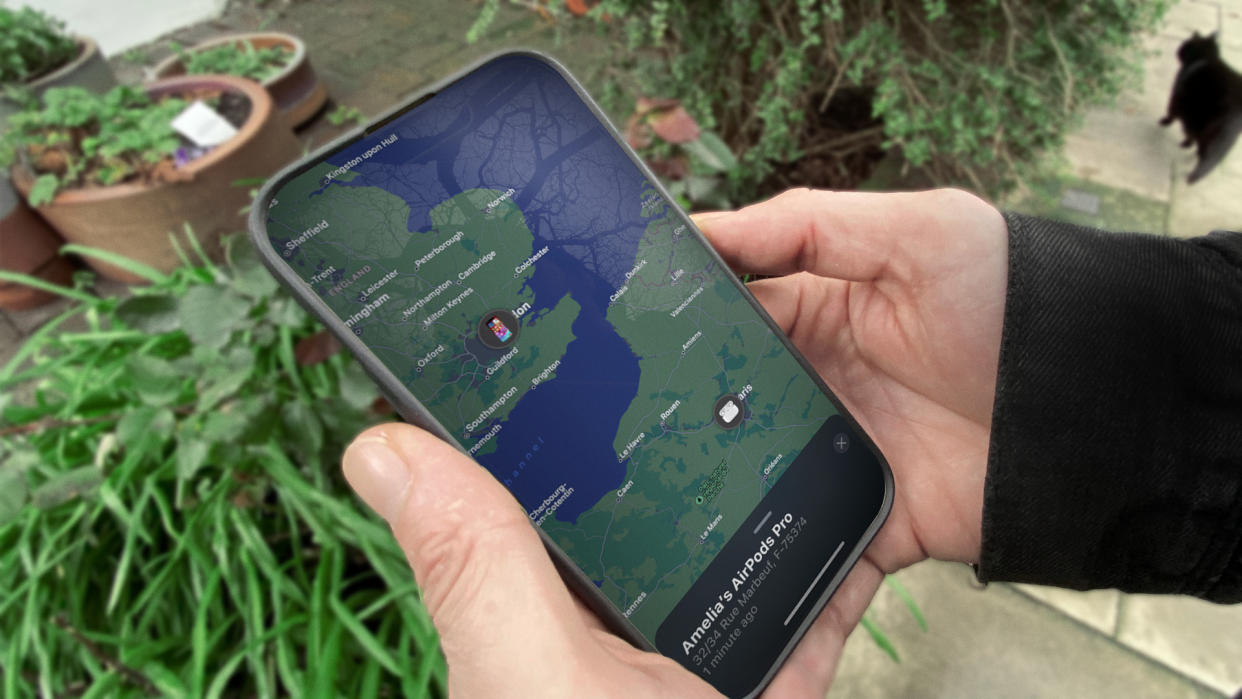  A person holds an iPhone with the Find My app open. 