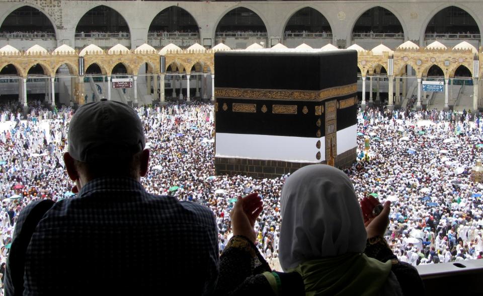 Muslim pilgrims pray as they watch thousands of pilgrims around the Kaaba. (AP)