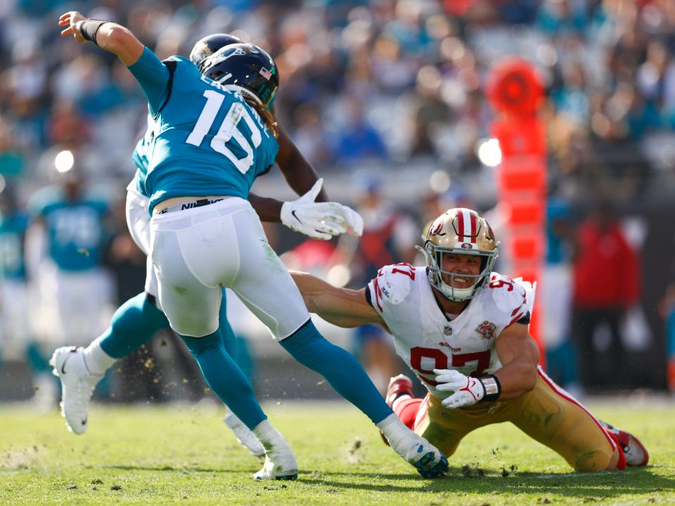 Nov 21, 2021; Jacksonville, Florida, USA; Jacksonville Jaguars quarterback Trevor Lawrence (16) avoids a rush from San Francisco 49ers defensive end Nick Bosa (97) in the second half at TIAA Bank Field.