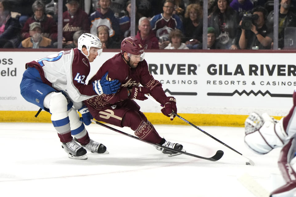 Arizona Coyotes left wing Jason Zucker (16) shields the puck from Colorado Avalanche defenseman Josh Manson in the second period during an NHL hockey game, Wednesday, Dec. 27, 2023, in Tempe, Ariz. (AP Photo/Rick Scuteri)