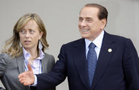 FILE — Italian Prime Minister Silvio Berlusconi, right, shares a word with Italian Minister for Youth Giorgia Meloni prior to a group photo of G8 and G5 leaders at the G8 summit in L'Aquila, Italy on Thursday, July 9, 2009. With God, homeland and "natural" family prominent in her political manifesto, Giorgia Meloni, whose Fratelli d'Italia (Brothers of Italy) party with neo-fascist roots has been fast rising in popularity in view of the upcoming Sept. 25 elections for Parliament, is positioning herself to become Italy's first far-right premier and the first woman to hold that office. (AP Photo/Stefano Rellandini, Pool)