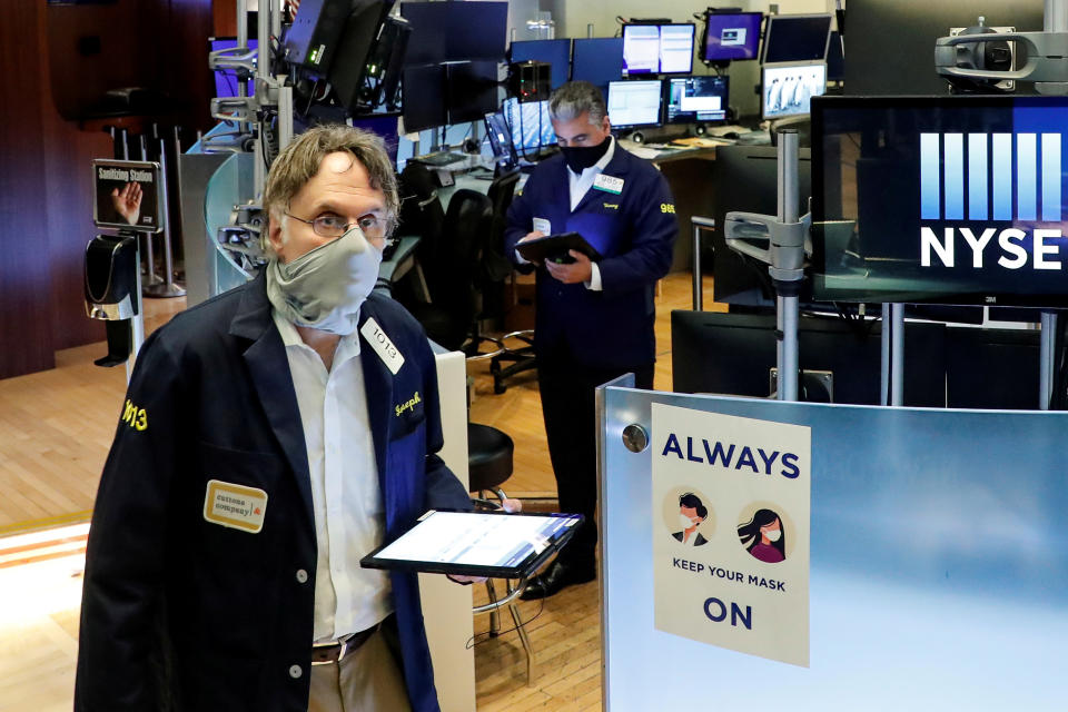 Traders wearing masks work, on the first day of in person trading since the closure during the outbreak of the coronavirus disease (COVID-19) on the floor at the New York Stock Exchange (NYSE) in New York, U.S., May 26, 2020. REUTERS/Brendan McDermid     TPX IMAGES OF THE DAY