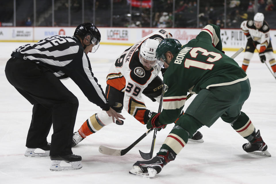 Linesman Ryan Galloway (82) drops the puck for faceoff between Anaheim Ducks' Sam Carrick (39) and Minnesota Wild's Nick Bonino (13) during the second period of an NHL hockey game Friday, May 7, 2021, in St. Paul, Minn. (AP Photo/Stacy Bengs)