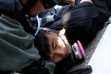 An anti-government protester is detained during a march in Tuen Mun, Hong Kong