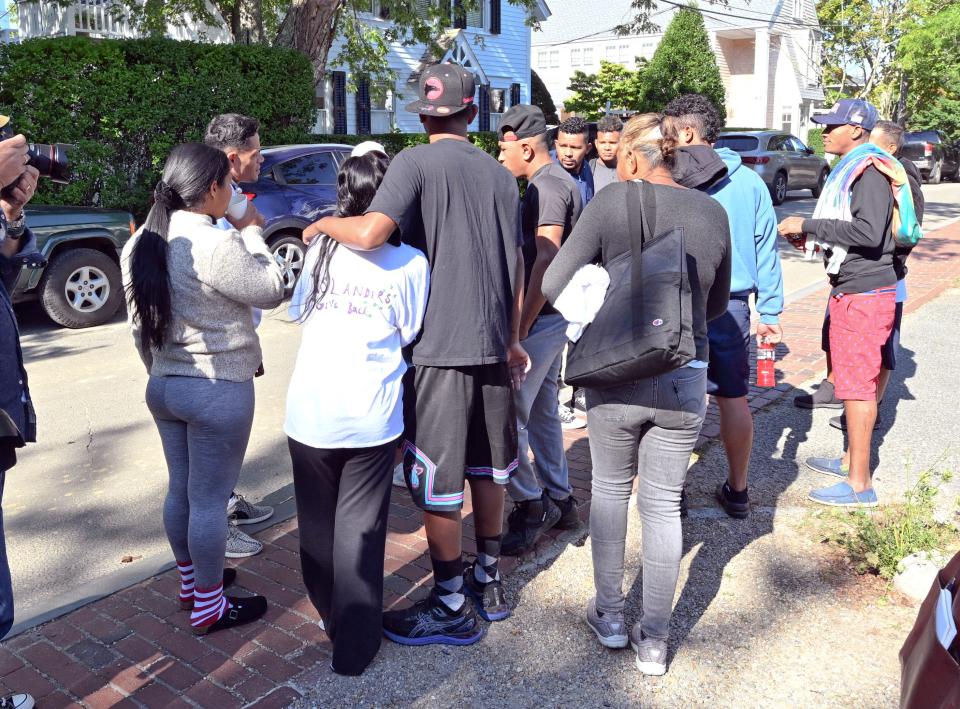 Migrants gather in front of the St. Andrews Parish Hall in Edgartown Thursday morning after arriving on Wednesday at the Martha's Vineyard Airport with no where to stay.