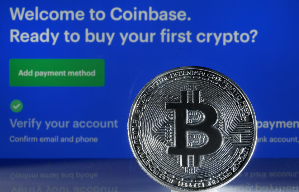 PARIS, FRANCE - FEBRUARY 26: In this photo illustration, a visual representation of the digital Cryptocurrency, Bitcoin is displayed in front of the Coinbase cryptocurrency exchange website on February 26, 2021 in Paris, France. Cryptocurrency trading platform Coinbase has filed for registration with the SEC on Thursday for an IPO via direct listing on the Nasdaq and will likely be the largest IPO of the year. Coinbase reported $ 1.28 billion in revenue in 2020 (+ 140% year on year), for net profit of $ 320 million. (Photo illustration by Chesnot/Getty Images)