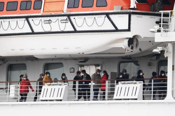 Passengers walk along the deck of the Diamond Princess cruise ship in February 2020. Around 3,600 people were quarantined onboard due to fears of a coronavirus outbreak (Photo by CHARLY TRIBALLEAU/AFP via Getty Images)