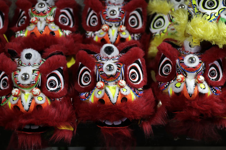 Miniature lion heads are prepared for delivery as members of a Dragon and Lion dance group seek other ways to earn a living at a creekside slum in Manila's Chinatown, Binondo, Philippines on Feb. 8, 2021. The Dragon and Lion dancers won't be performing this year after the Manila city government banned the dragon dance, street parties, stage shows or any other similar activities during celebrations for Chinese New Year due to COVID-19 restrictions leaving several businesses without income as the country grapples to start vaccination this month. (AP Photo/Aaron Favila)