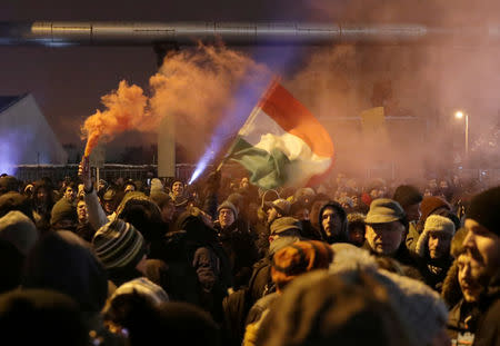 FILE PHOTO: People attend a protest against a proposed new labor law, billed as the "slave law", outside the headquarters of the Hungarian state television in Budapest, Hungary, December 17, 2018. REUTERS/Marko Djurica