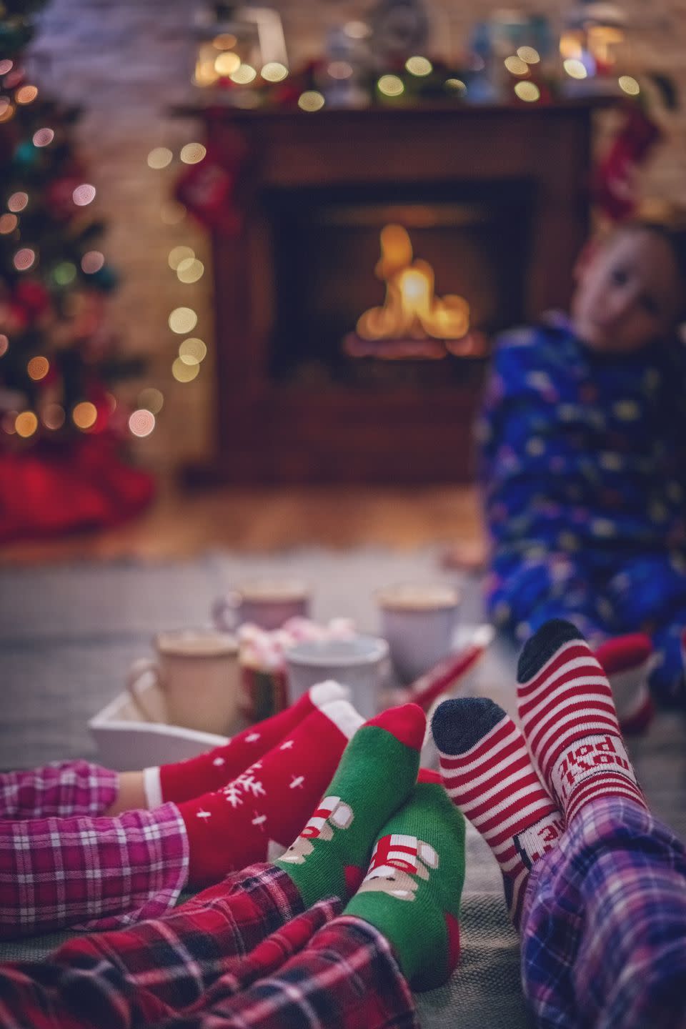 <p>Throw on your matching Christmas jammies and your <a href="https://www.oprahmag.com/style/g28614181/fuzzy-christmas-socks/" rel="nofollow noopener" target="_blank" data-ylk="slk:fuzziest socks;elm:context_link;itc:0;sec:content-canvas" class="link ">fuzziest socks</a>, arrange sleeping bags under the tree, and have a family sleepover under the twinkling lights.</p>