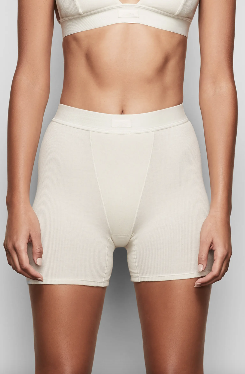 model in white bra and white Skims Cotton Rib Boxers (Photo via Nordstrom)