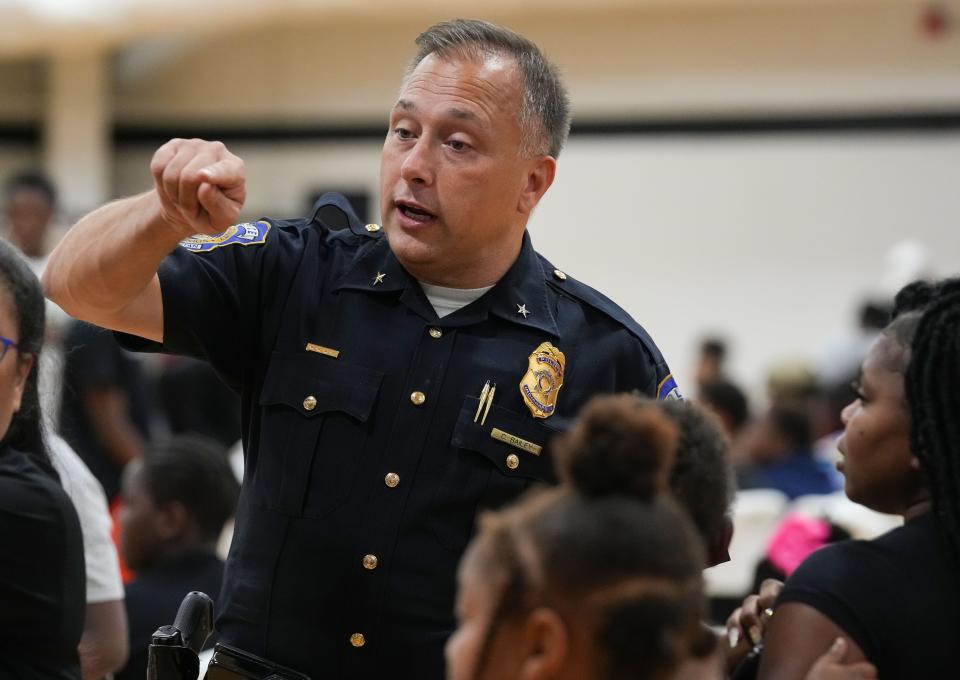 IMPD Assistant Chief Chris Bailey helps direct guests Tuesday, Aug. 29, 2023, during the Back to School Essential Giveaway to Empower Indianapolis Students at the JTV Hill Center in Indianapolis.