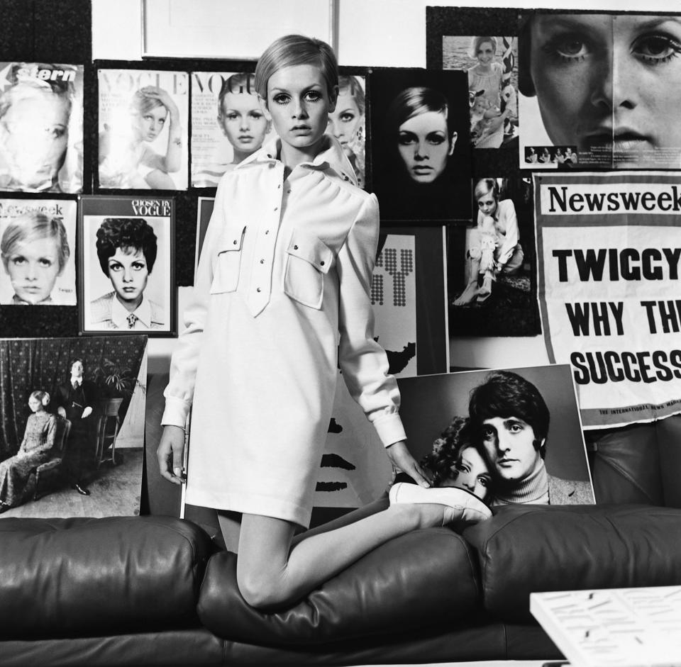 Twiggy models a shirt dress amid posters of her previous work.