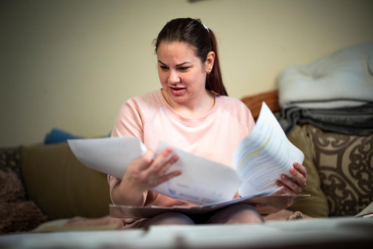 Sarah Duckett files through paperwork from her breast augmentation in her Valrico, Florida home. Duckett traveled to Columbus for her surgery, which was performed by Dr. Katharine Roxanne Grawe, better known on social media as Dr. Roxy. Sarah's own 2021 procedure was posted on social media and she said she is still suffering from complications from it.