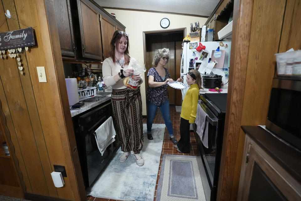 Estella Baraniak's mother Ashley Snyder and grandmother Jackie Baraniak prepare an afterschool snack for Estella, right, in Halifax, Pa., Wednesday, March 6, 2024. Across the country, it's not uncommon for the relatives of prisoners who died on the job to struggle with determining who's liable. When workers' compensation is offered, the amount awarded is typically determined by the size of the worker's paycheck and usually closes the door on future wrongful death suits. (AP Photo/Matt Rourke)