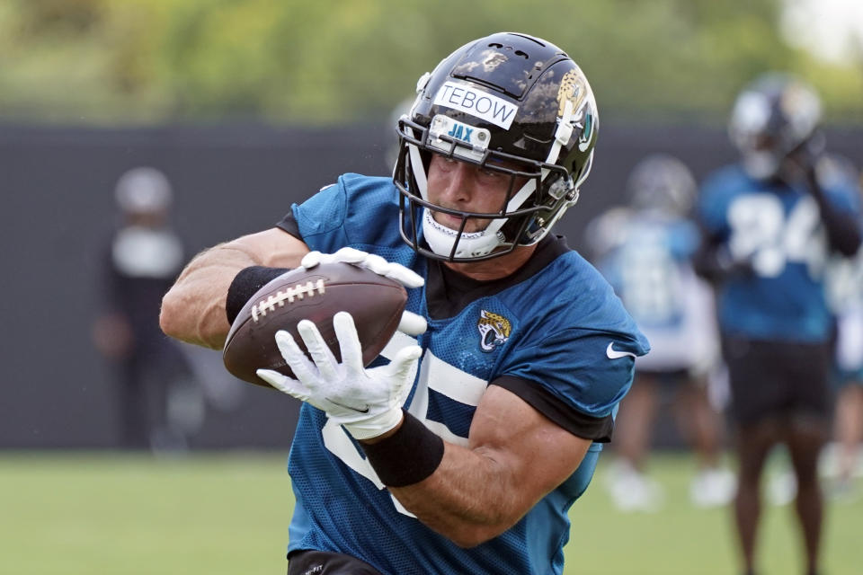 FILE - Jacksonville Jaguars tight end Tim Tebow catches a pass during NFL football practice in Jacksonville, Fla., in this Thursday, May 27, 2021, file photo. Tebow’s far from the spotlight, right where coach Urban Meyer wants the 2007 Heisman Trophy winner for now. (AP Photo/John Raoux, File)