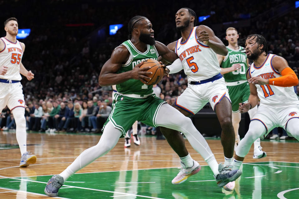 Boston Celtics guard Jaylen Brown, left, drives to the basket against New York Knicks guard Immanuel Quickley (5) during the first half of an NBA basketball game, Friday, Dec. 8, 2023, in Boston. (AP Photo/Charles Krupa)