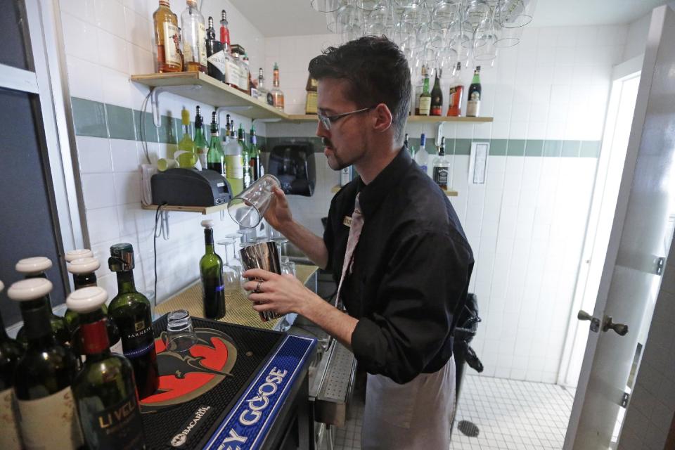 FILE - In this Feb. 26, 2013, file photo, manager Dustin Humes fixes a drink in a small room which is out of the view of patrons at Vivace Restaurant, in Salt Lake City. The Mormon church has issued a sweeping defense of Utah's famously strict liquor laws, drawing a line against tourism, restaurant and bar industry advocates who have helped ease alcohol regulations in recent years. Ahead of the upcoming legislative session, The Church of Jesus Christ of Latter-day Saints posted to its website a hefty multimedia policy statement urging lawmakers to uphold rules that church leaders say are "closely tied to the moral culture of the state." (AP Photo/Rick Bowmer, File)
