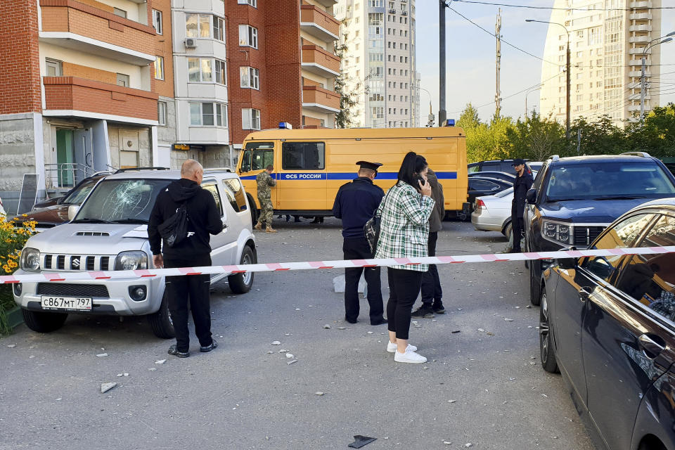 Investigators work at the site of the place where the downed Ukrainian drone fell in Krasnogorsk, just outside Moscow, Russia, Tuesday, Aug. 22, 2023. Andrei Vorobyov, the governor of the Moscow region, said that two Ukrainian drones were shot down by air defenses on western outskirts of the Russian capital early Tuesday. (Moscow News Agency via AP)