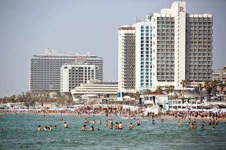 People swim in the Mediterranean Sea as they enjoy themselves at the beach during Israel's parliamentary election day, in Tel Aviv, Israel April 9, 2019. REUTERS/Corinna Kern