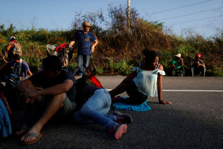 Eight months pregnant Honduran migrant Erly Marcial, 21, rests with fellow migrants on the road that links Tapanatepec and Santo Domingo Ingenio, near Tapanatepec, Mexico, November 7, 2018. REUTERS/Carlos Garcia Rawlins