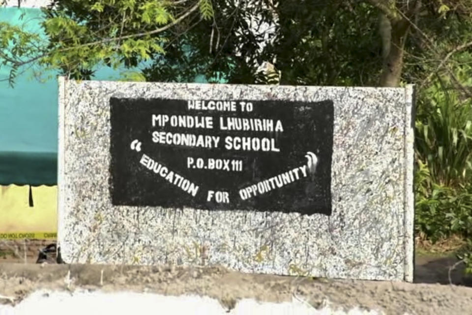This image made from video shows the sign of the Lhubiriha Secondary School following an attack on the school near the border with Congo, in Mpondwe, Uganda Saturday, June 17, 2023. Ugandan authorities recovered the bodies of dozens of people including students who were burned, shot or hacked to death after suspected rebels attacked the school, the local mayor said Saturday, June 17, 2023. (AP Photo)